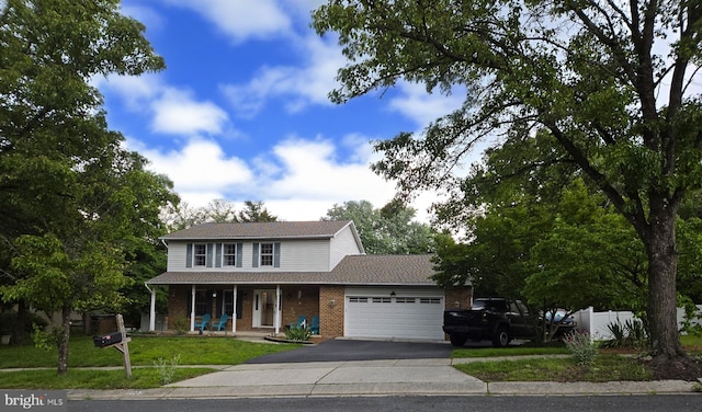 7907 Elberta Dr, Severn, MD 21144 - traditional-style home with a porch, a garage, asphalt driveway, brick siding, and a front yard