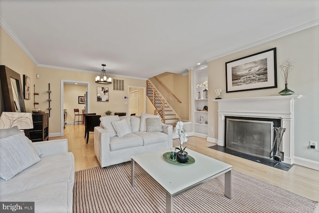 1618 Belmont St NW Unit D, Washington, DC 20009 - living room featuring ornamental molding, stairway, a chandelier, light wood finished floors, and a fireplace with flush hearth
