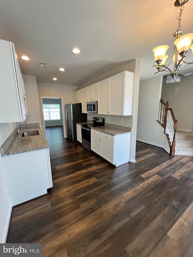 12112 Bowling Farm Ct, Fredericksburg, VA 22407 - kitchen featuring appliances with stainless steel finishes, white cabinetry, light stone counters, a chandelier, and dark wood-type flooring