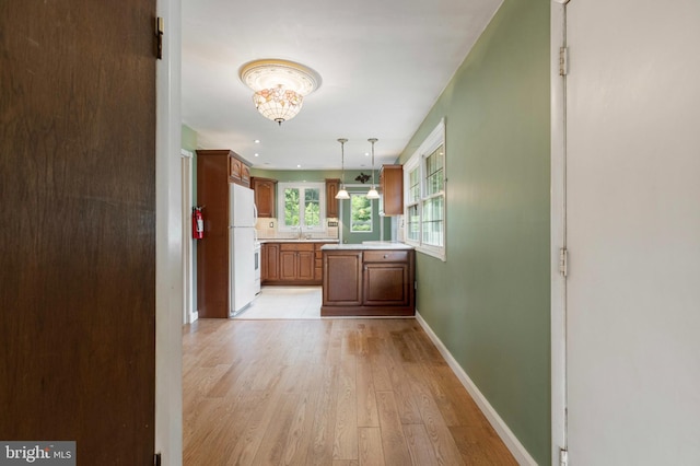 21 Jerrys Ave, Clayton, NJ 08312 - kitchen with freestanding refrigerator, light countertops, light wood-style flooring, hanging light fixtures, and brown cabinetry