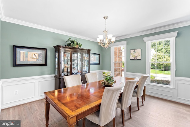 43251 Brownstone Ct, Ashburn, VA 20147 - dining room with wainscoting, a chandelier, light wood finished floors, crown molding, and a decorative wall