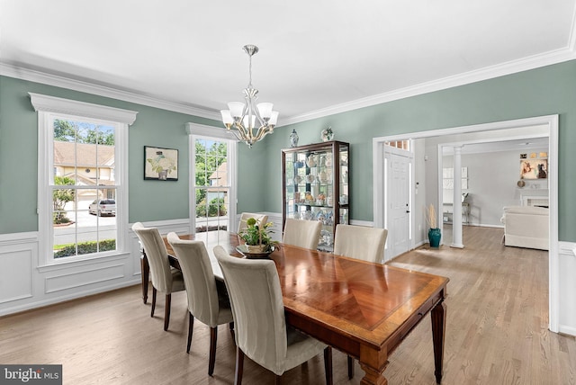 43251 Brownstone Ct, Ashburn, VA 20147 - dining room with a chandelier, light wood-style flooring, crown molding, and wainscoting