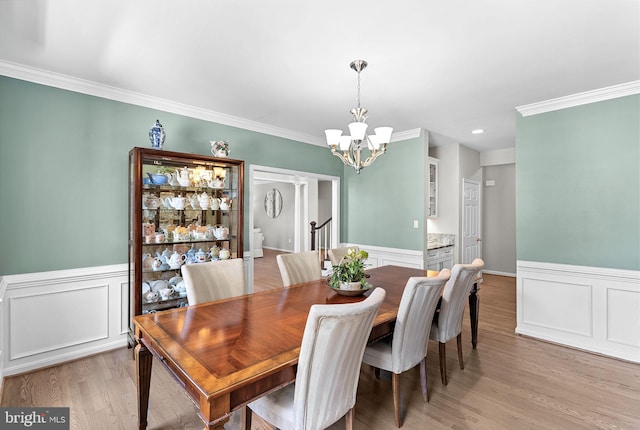 43251 Brownstone Ct, Ashburn, VA 20147 - dining area featuring a chandelier, a wainscoted wall, ornamental molding, and light wood-style flooring