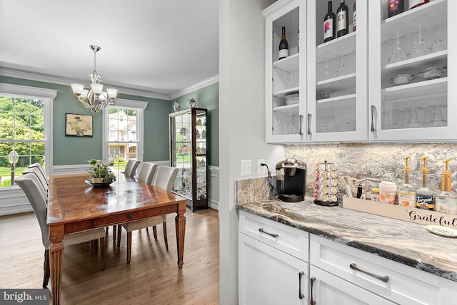 43251 Brownstone Ct, Ashburn, VA 20147 - dining area featuring light wood-style floors, a chandelier, and ornamental molding