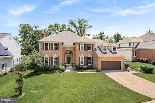43251 Brownstone Ct, Ashburn, VA 20147 - colonial-style house with brick siding, concrete driveway, a front yard, a chimney, and an attached garage