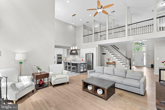 43251 Brownstone Ct, Ashburn, VA 20147 - living area with a ceiling fan, stairway, a high ceiling, light wood-style flooring, and recessed lighting