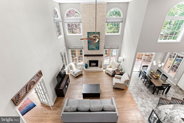 43251 Brownstone Ct, Ashburn, VA 20147 - living room featuring a high ceiling, a fireplace, ceiling fan, and wood finished floors