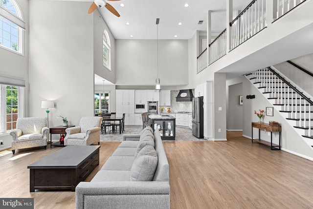 43251 Brownstone Ct, Ashburn, VA 20147 - living area with a high ceiling, a ceiling fan, light wood-style floors, stairs, and recessed lighting