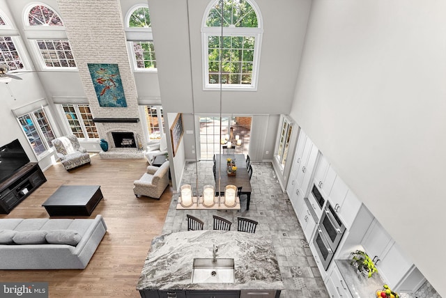43251 Brownstone Ct, Ashburn, VA 20147 - living area featuring a high ceiling, wood finished floors, and a fireplace
