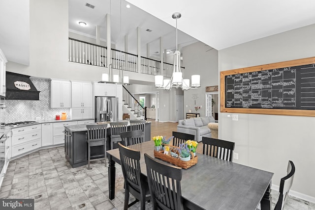 43251 Brownstone Ct, Ashburn, VA 20147 - dining space featuring a towering ceiling, a chandelier, and stairs