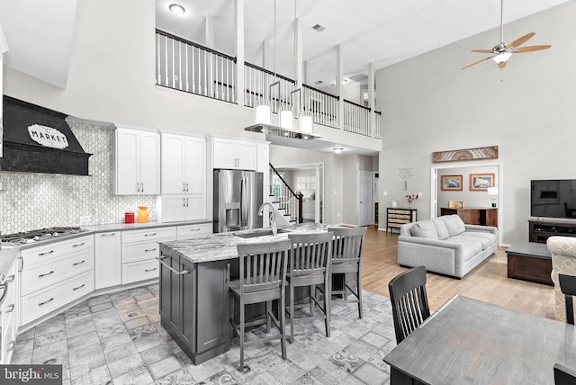 43251 Brownstone Ct, Ashburn, VA 20147 - kitchen featuring stainless steel appliances, high vaulted ceiling, ceiling fan, white cabinetry, and open floor plan