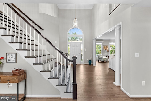 43251 Brownstone Ct, Ashburn, VA 20147 - foyer with wood finished floors, stairway, a towering ceiling, ornate columns, and crown molding