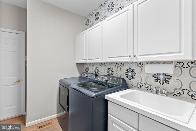 43251 Brownstone Ct, Ashburn, VA 20147 - laundry room with separate washer and dryer, cabinet space, and light wood-style floors