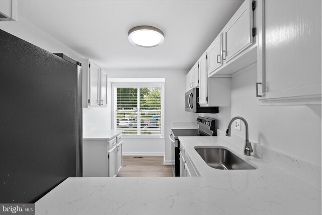 5840 Wescott Hills Way, Alexandria, VA 22315 - laundry room with a sink and light wood-style floors