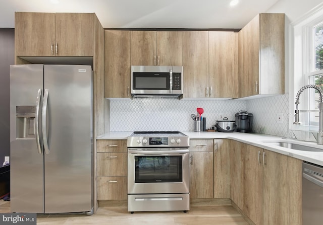 2246 N Hancock St, Philadelphia, PA 19133 - kitchen featuring appliances with stainless steel finishes, light countertops, light wood-style flooring, and tasteful backsplash