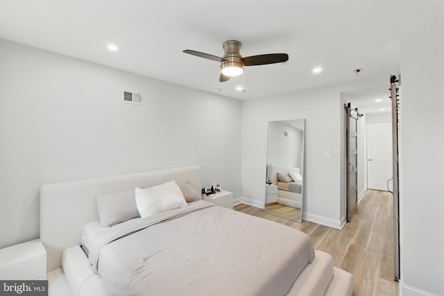2246 N Hancock St, Philadelphia, PA 19133 - bedroom featuring a barn door, recessed lighting, light wood-style flooring, and ceiling fan