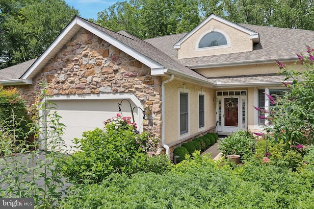 130 Piqua Cir Unit 30, Berwyn, PA 19312 - view of front of home with stone siding, a shingled roof, an attached garage, and stucco siding