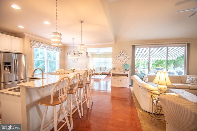 37126 Solitude Dr, Selbyville, DE 19975 - kitchen featuring stainless steel fridge with ice dispenser, ceiling fan, open floor plan, wood finished floors, and ornamental molding