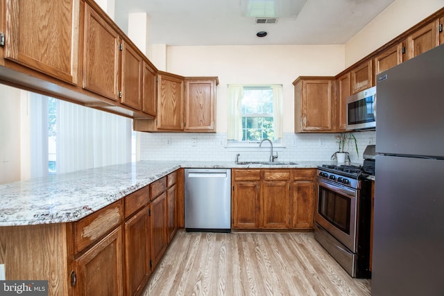 23 Navesink Dr, Pennington, NJ 08534 - kitchen with stainless steel appliances, light wood-style flooring, a peninsula, and brown cabinets