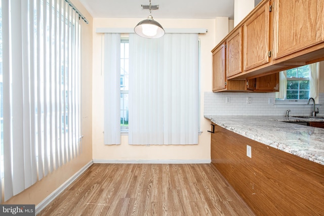 23 Navesink Dr, Pennington, NJ 08534 - kitchen featuring light wood-style floors, backsplash, light stone countertops, brown cabinets, and hanging light fixtures
