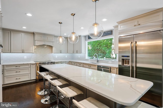 2707 E Ridge Ct, Oakton, VA 22124 - kitchen featuring appliances with stainless steel finishes, a kitchen island, a kitchen breakfast bar, light stone countertops, and custom range hood