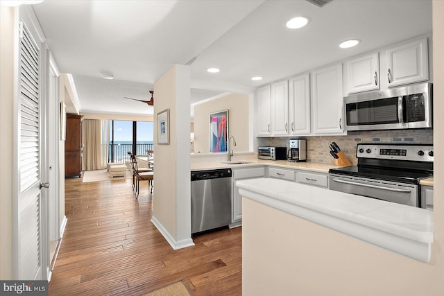 403 N Edgewater House Rd Unit 403N, Bethany Beach, DE 19930 - kitchen featuring stainless steel appliances, backsplash, light wood-style flooring, white cabinetry, and light countertops