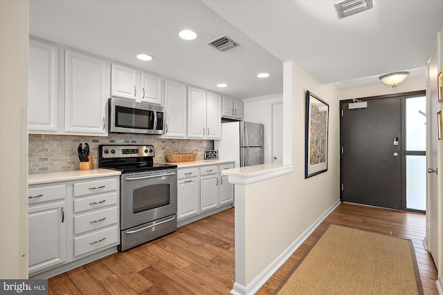 403 N Edgewater House Rd Unit 403N, Bethany Beach, DE 19930 - kitchen featuring stainless steel appliances, light wood-type flooring, white cabinetry, tasteful backsplash, and recessed lighting