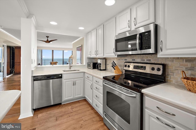 403 N Edgewater House Rd Unit 403N, Bethany Beach, DE 19930 - kitchen with stainless steel appliances, backsplash, light wood-style floors, recessed lighting, and crown molding