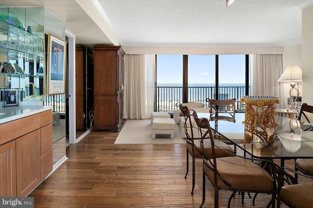 403 N Edgewater House Rd Unit 403N, Bethany Beach, DE 19930 - dining room with dark wood-type flooring, a water view, a textured ceiling, and expansive windows