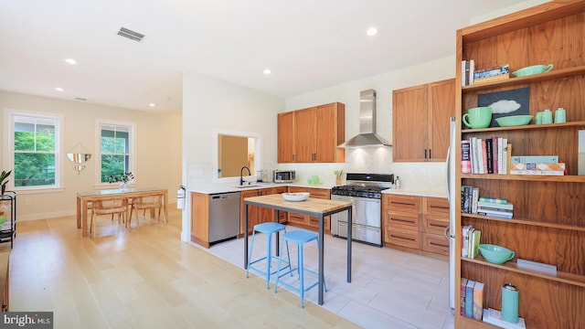 18 Hart Ave, Hopewell, NJ 08525 - kitchen featuring wall chimney exhaust hood, appliances with stainless steel finishes, light countertops, tasteful backsplash, and light wood-style flooring