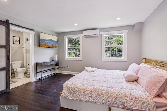 1707 Peach St, Upper Chichester, PA 19061 - bedroom with a wall unit AC, wood finished floors, a barn door, recessed lighting, and ensuite bathroom