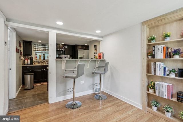 1707 Peach St, Upper Chichester, PA 19061 - kitchen with stainless steel refrigerator with ice dispenser, light wood-style floors, a breakfast bar, recessed lighting, and light countertops