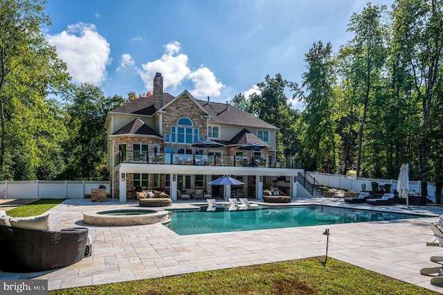 11204 Fawn Lake Pkwy, Spotsylvania, VA 22551 - back of house with a balcony, stone siding, a patio area, a fenced backyard, and a chimney