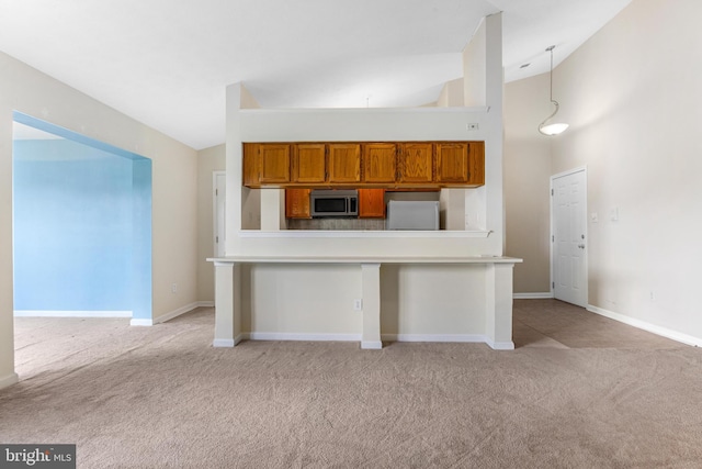 7854 Cornerstone Way Unit 8-7854, Windsor Mill, MD 21244 - kitchen with stainless steel microwave, freestanding refrigerator, light carpet, brown cabinetry, and light countertops