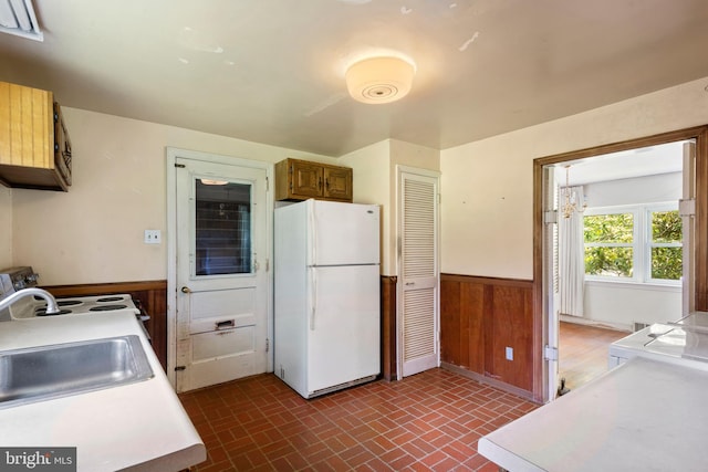 214 Sugartown Rd, Devon, PA 19333 - kitchen with freestanding refrigerator, a wainscoted wall, brick patterned floors, wood walls, and light countertops