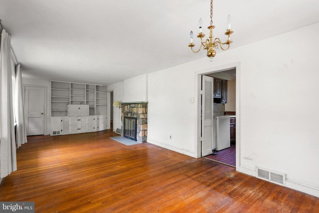 214 Sugartown Rd, Devon, PA 19333 - unfurnished living room featuring a chandelier, hardwood / wood-style flooring, a fireplace, and built in features