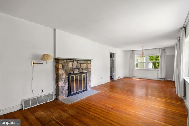 214 Sugartown Rd, Devon, PA 19333 - unfurnished living room featuring a chandelier, wood finished floors, and a fireplace