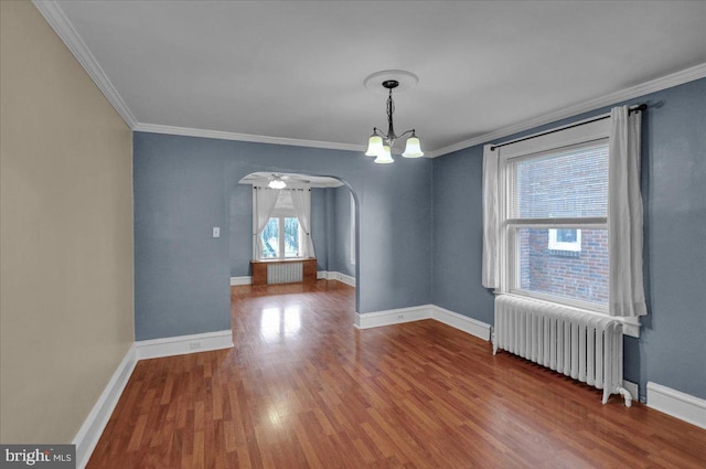 210 N Waverly St, Reading, PA 19607 - unfurnished room with radiator heating unit, ornamental molding, wood finished floors, a chandelier, and arched walkways