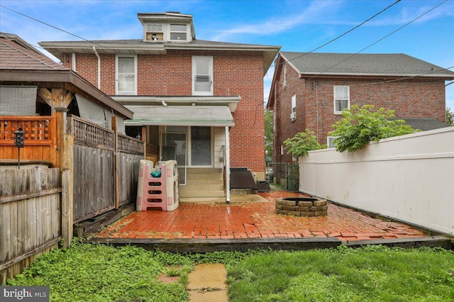 210 N Waverly St, Reading, PA 19607 - rear view of property featuring a fire pit, a fenced backyard, brick siding, and a patio area