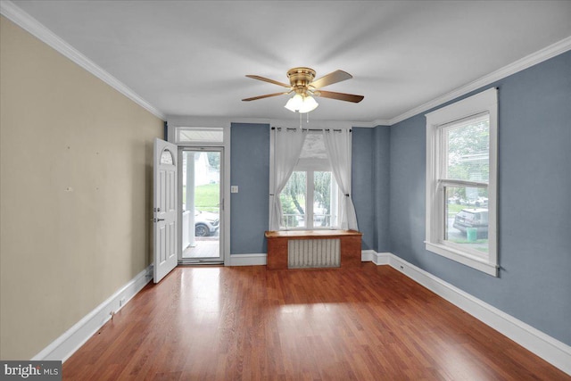 210 N Waverly St, Reading, PA 19607 - empty room featuring healthy amount of natural light, ceiling fan, radiator heating unit, wood finished floors, and crown molding