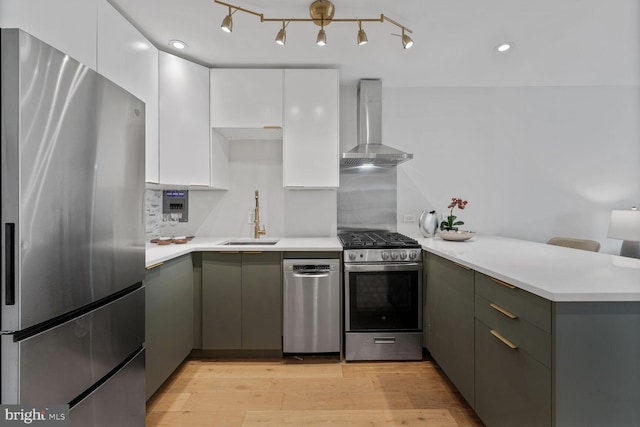 2829 Connecticut Ave NW Unit 706, Washington, DC 20008 - kitchen with stainless steel appliances, wall chimney range hood, a peninsula, and light countertops
