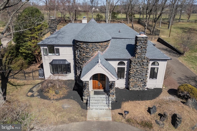 4127 Presidential Dr, Lafayette Hill, PA 19444 - french provincial home with a chimney, stone siding, a shingled roof, and stucco siding
