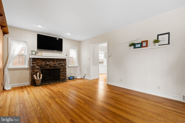 207 Commonwealth Ave, Claymont, DE 19703 - unfurnished living room with wood finished floors, a stone fireplace, and recessed lighting