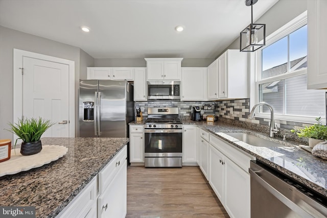 92 Senators Way, Berlin, NJ 08009 - kitchen with stainless steel appliances, white cabinetry, tasteful backsplash, light wood-type flooring, and hanging light fixtures