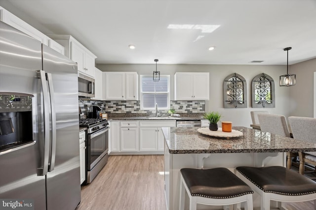 92 Senators Way, Berlin, NJ 08009 - kitchen featuring appliances with stainless steel finishes, a breakfast bar, tasteful backsplash, white cabinetry, and dark stone counters