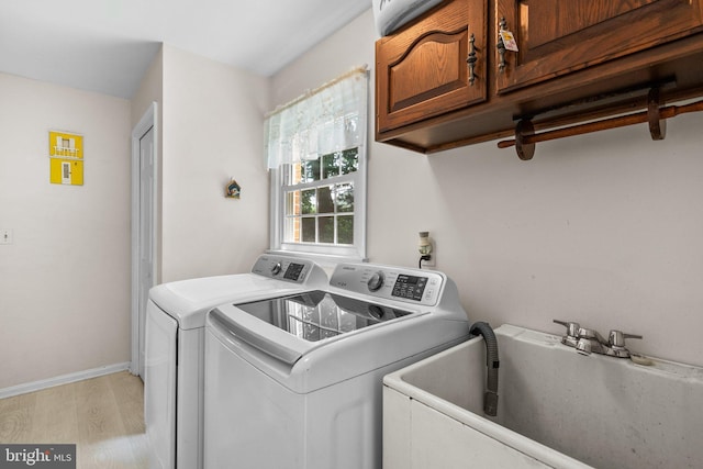 24411 Kakae Dr, Damascus, MD 20872 - laundry room with light wood-style flooring, cabinet space, and washing machine and clothes dryer