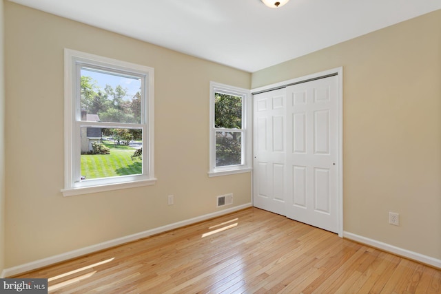 11013 Lopa Ln, North Potomac, MD 20878 - unfurnished bedroom with hardwood / wood-style floors, multiple windows, and a closet