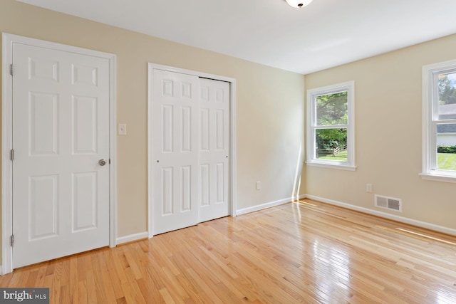 11013 Lopa Ln, North Potomac, MD 20878 - unfurnished bedroom featuring light wood-style floors, multiple windows, and a closet