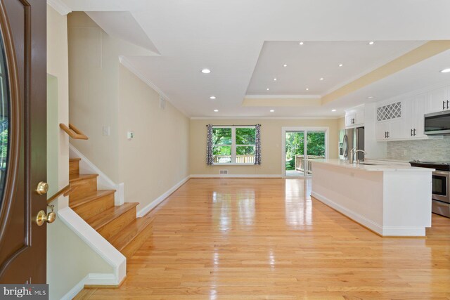 11013 Lopa Ln, North Potomac, MD 20878 - kitchen featuring stainless steel appliances, white cabinetry, light wood-style flooring, crown molding, and backsplash