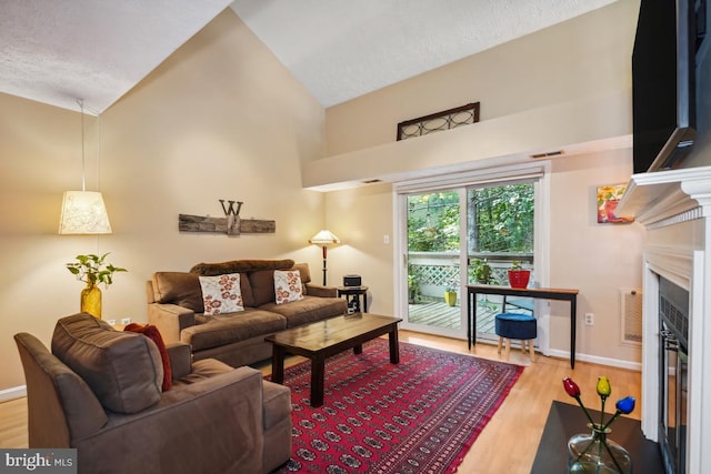 84 Windbrooke Cir Unit 84, Gaithersburg, MD 20879 - living area with a fireplace with flush hearth, wood finished floors, and high vaulted ceiling
